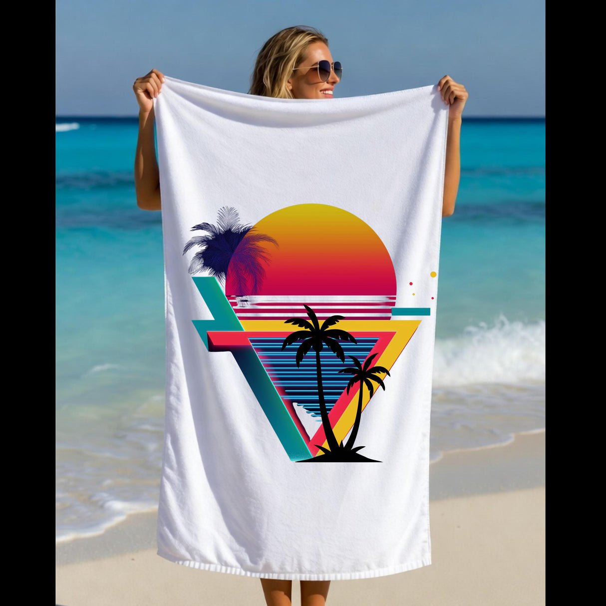 A woman on a beach holds up a white beach towel featuring a colorful retro sunset and palm tree graphic.