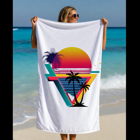 A woman on a beach holds up a white beach towel featuring a colorful retro sunset and palm tree graphic.