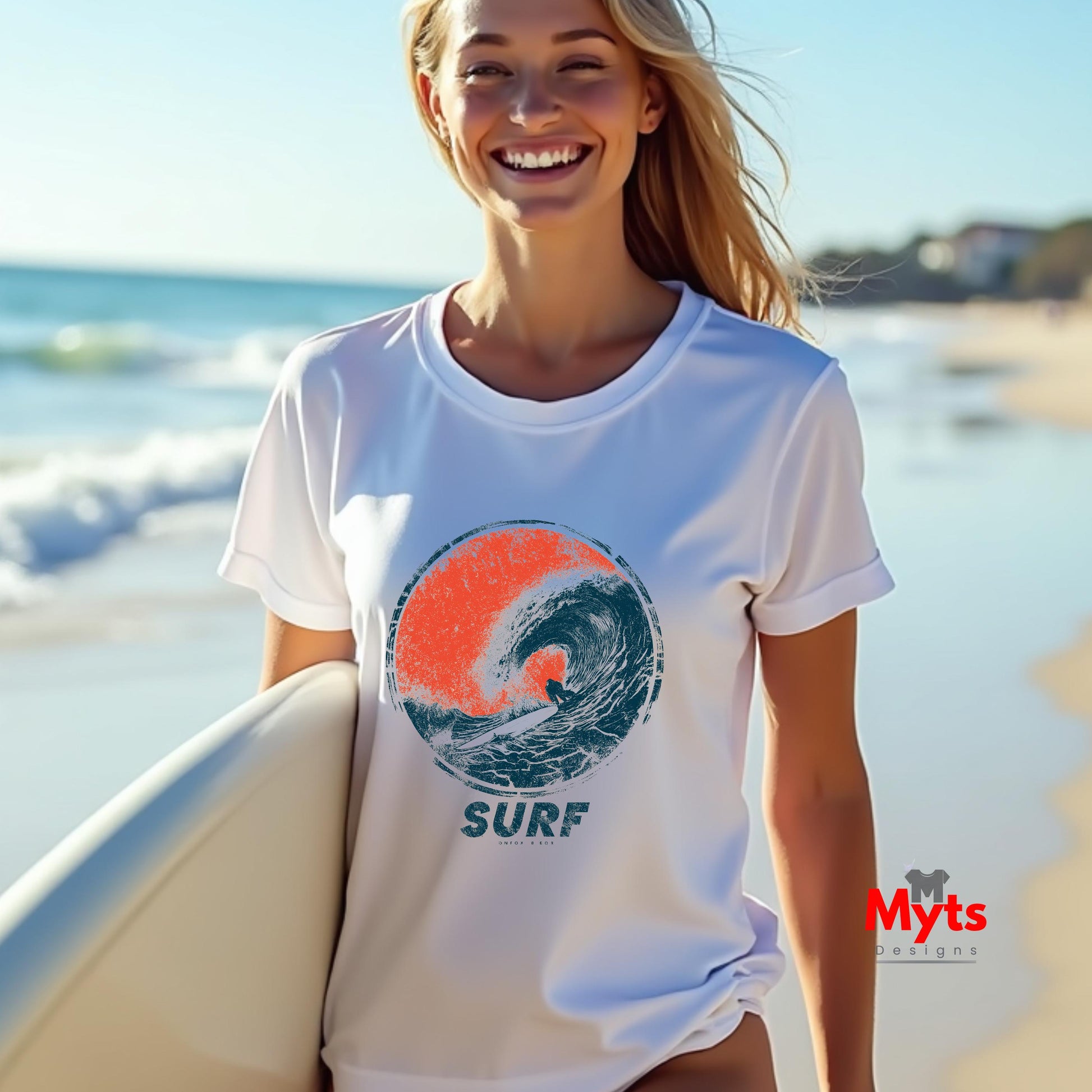A woman smiling on a beach while wearing a white short-sleeve t-shirt with a circular wave graphic in orange and dark blue, with the word 'SURF' printed below. She is holding a surfboard, with the ocean and sandy beach blurred in the background.