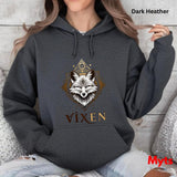 Person wearing a dark heather hoodie with a fox design and 'Vixen' text, sitting on a textured surface.
