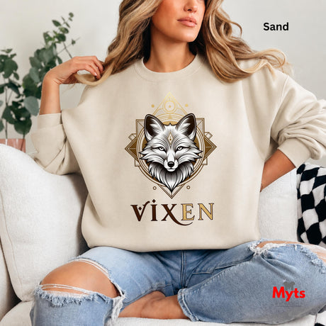 Person wearing a sand sweatshirt with a fox design and 'Vixen' text, sitting on a couch.